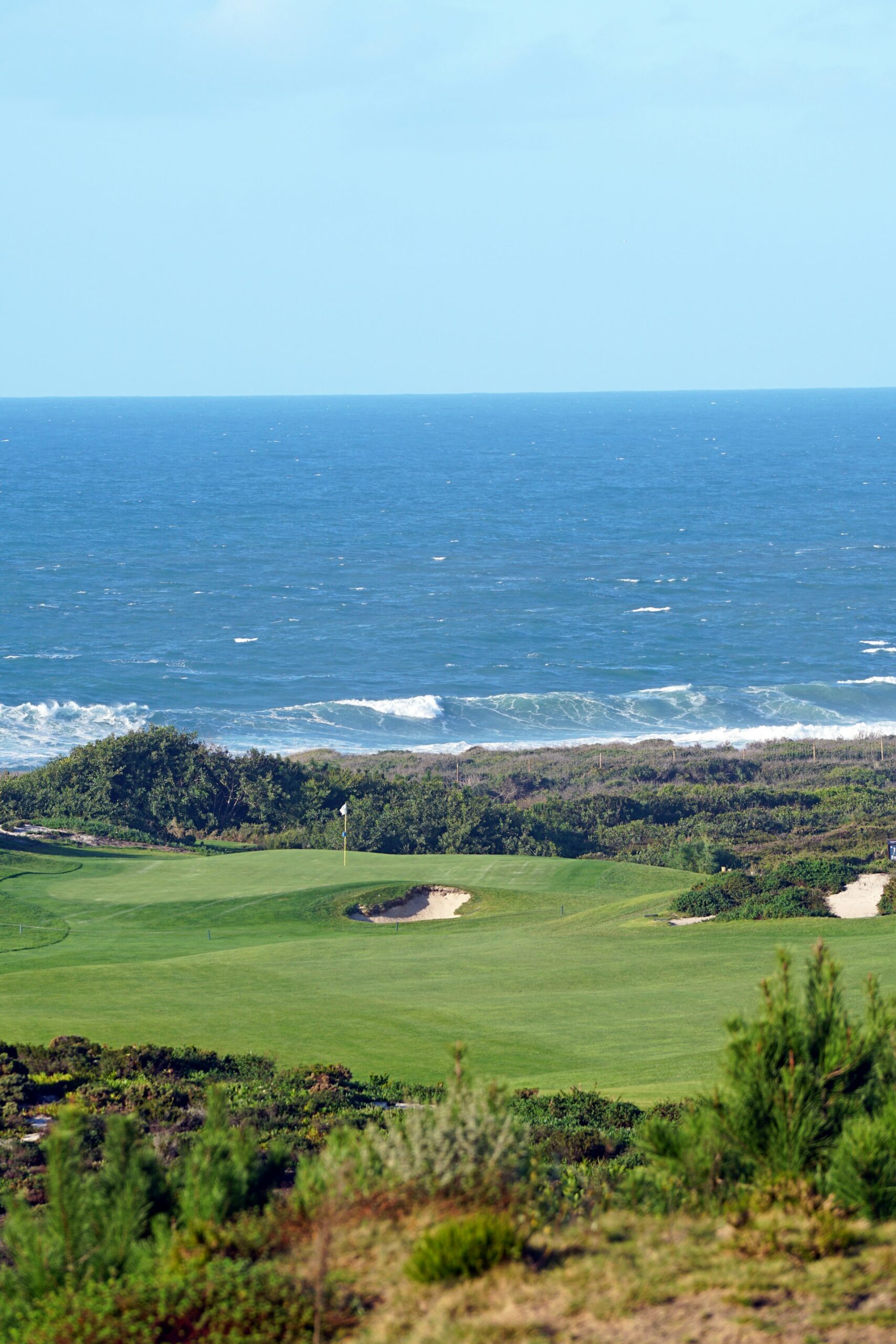 Golf green overlooking crashing ocean waves